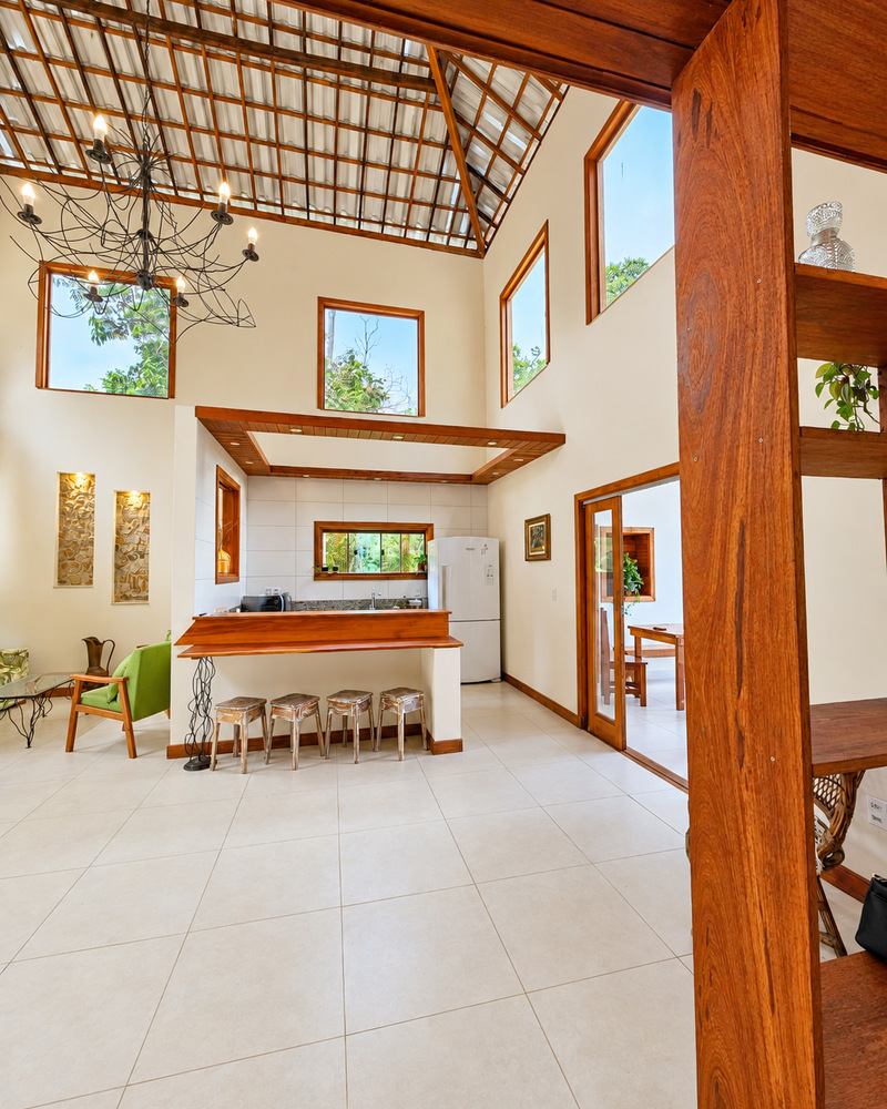 Sala integrada e cozinha sob o pé-direito alto de madeira