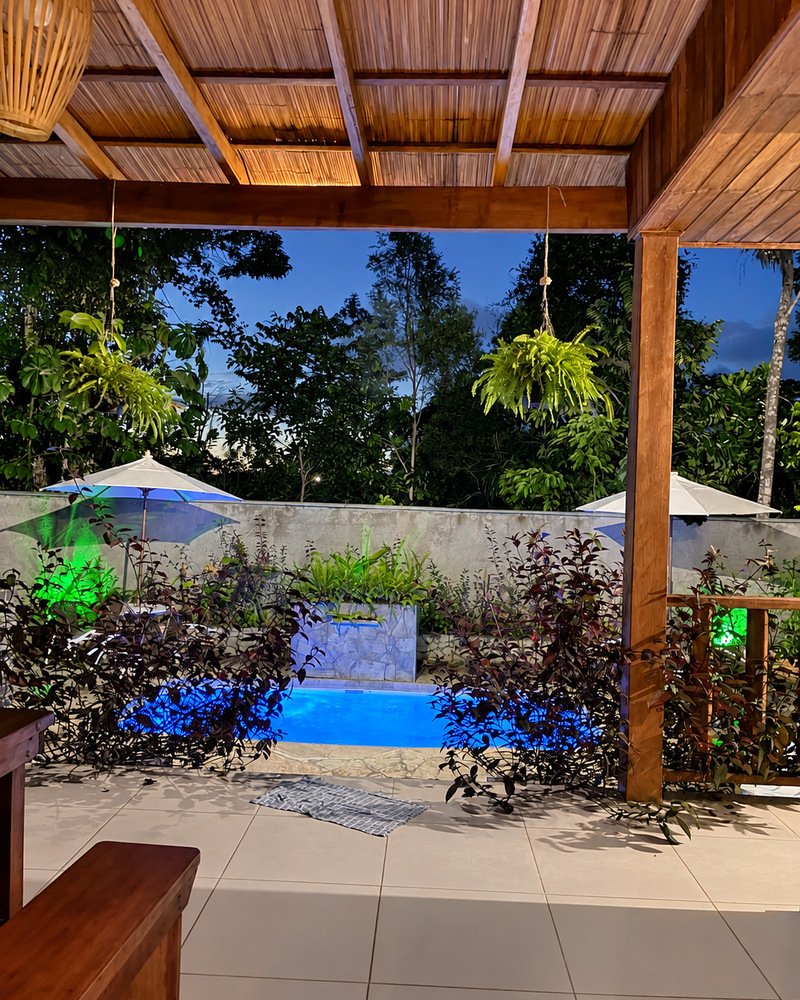 Piscina iluminada à noite vista da varanda da Casa Verde